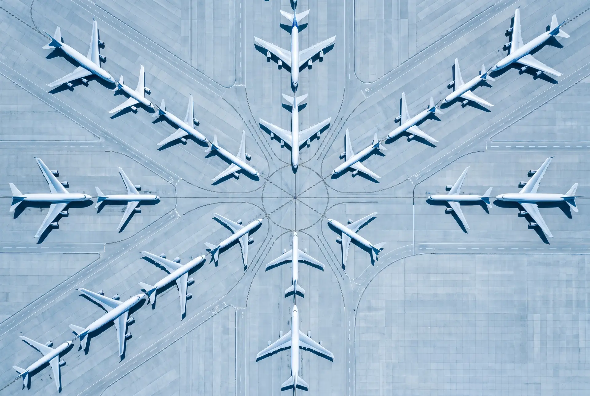 Aerial view of airplanes arranged in a radial pattern on airport aprons