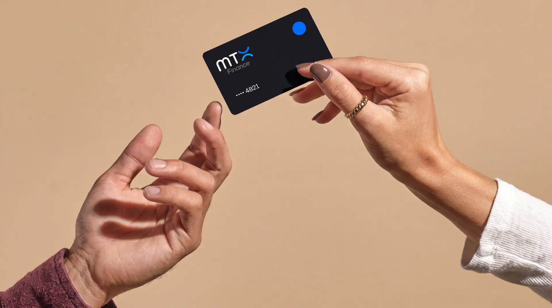 Two hands exchanging a black MTX Finance payment card